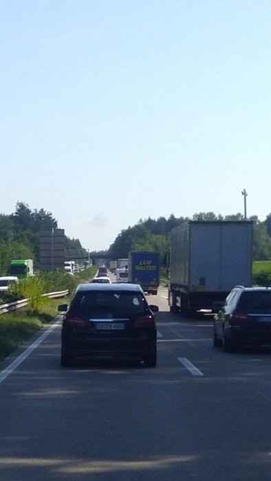 Trafik på en flerfilig motorväg under en solig dag.