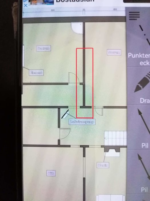 Ritning av bostadsplan med markerat område i rött runt en framtida luftvärmepump position.