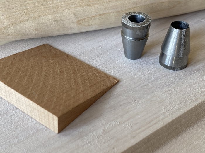 Verktygsdelar på arbetsbänk: Kölrundel och hylsa, troligen använda för yxreparation.