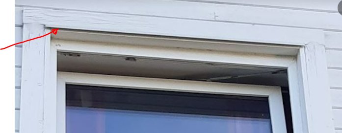 Detalj av fönsteröverdel med överbleck placerat under träfodret markerat med röd pil.