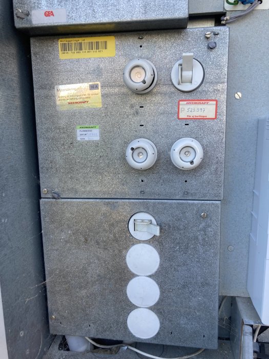Elektricitetscentral med etiketter, säkringar, och anslutningar för byggprojekt.