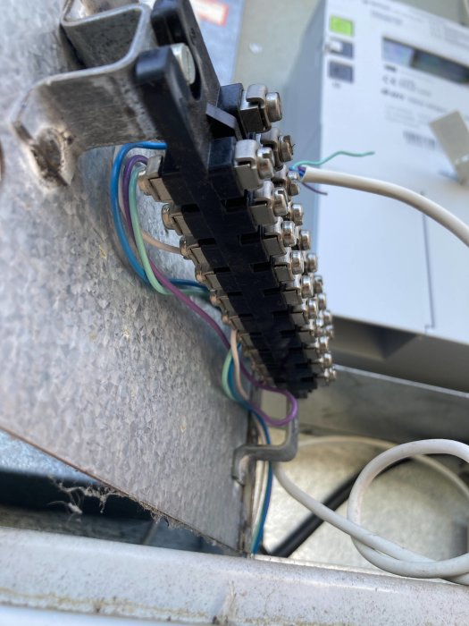 Elektrisk anslutningsplint med lösa kablar och skruvkontakter i en elcentral.