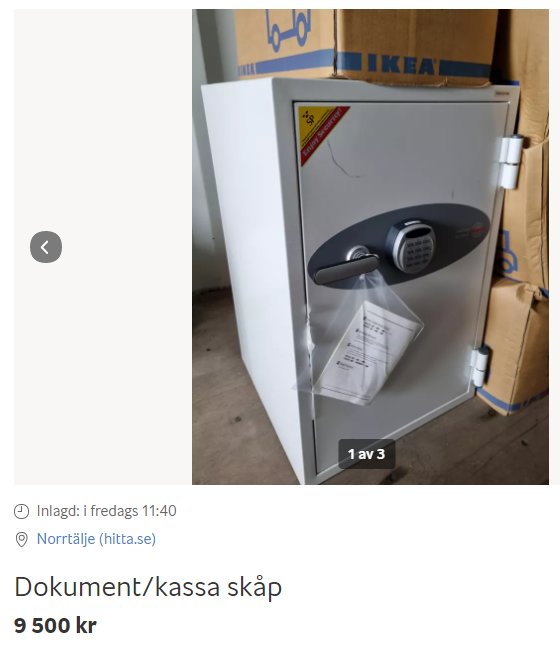 Ett vitt kassaskåp med elektroniskt lås framför en IKEA-kartong.