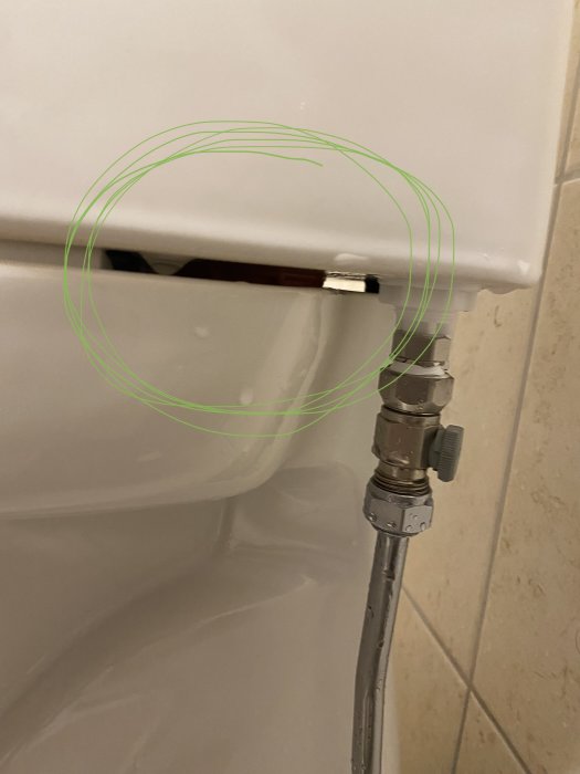 Toalett med synlig anslutning och grönt markerat område som visar ett problem.