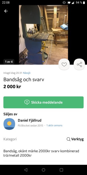 Bandsåg i en verkstad med träkonstruktioner i bakgrunden.