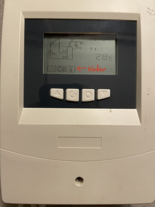 Kontrollpanel för värmesystem med blinkande symbol och temperaturvisning 28°C.