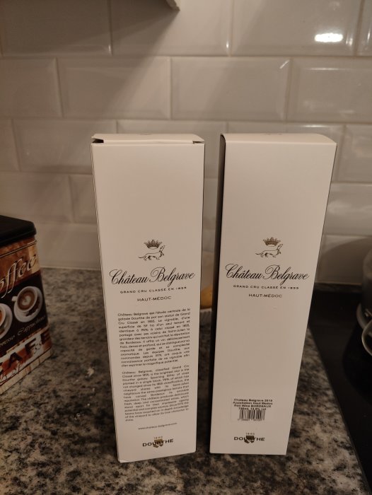 Två lådor av Château Belgrave Haut-Médoc vin står på en köksbänk.