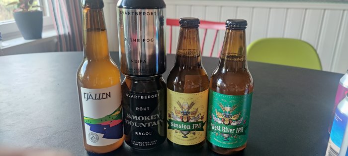 Fyra olika ölflaskor från Sälens Fjällbryggeri och Svartbergets Fjällbryggeri på ett bord.