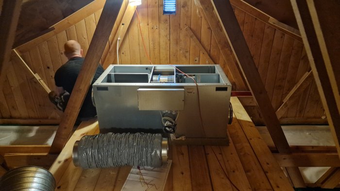 Installation av ett ventilationsaggregat på vinden med isolerade kanaler och tillbehör synliga.