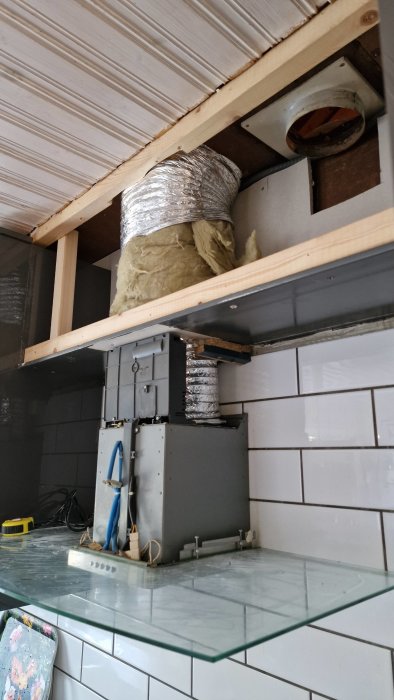 Renoverad köksventilation med ny kanal och isolering ovanför spisfläkten.
