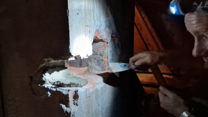 Person som applicerar bruk på murstock för installation av kanal.