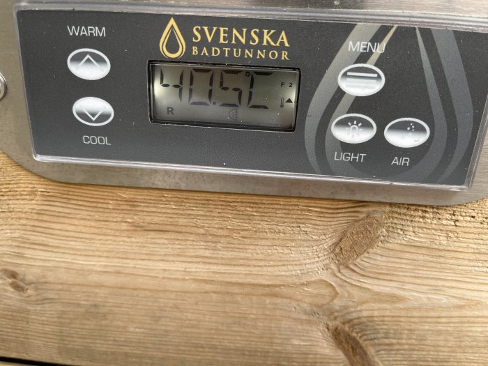 Digital display på en poolkontrollpanel som visar en temperatur på 41,5 grader Celsius.