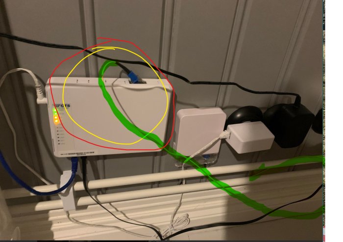 En fiberanslutningsinstallation med sladdar utsatta för potentiell skada och inkorrekt routing.