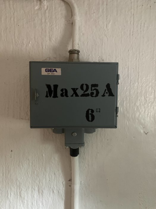 Eluttag märkt "Max 25A" på en vägg, med gammal ledning och installationsbox.