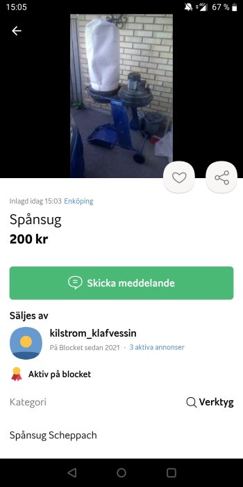 Begagnad blå spånsug Scheppach med vit uppsamlingspåse mot tegelvägg, utomhus.