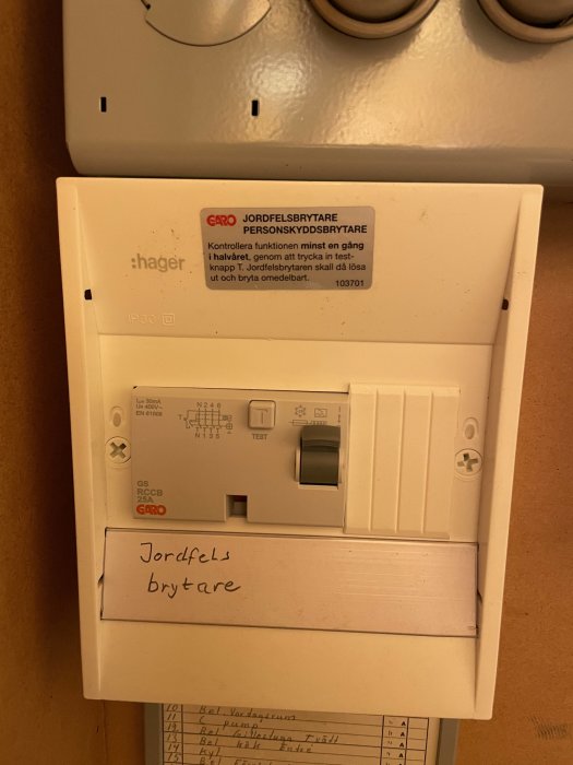 Installerad jordfelsbrytare och personskyddsbrytare i elskåp med testknapp.
