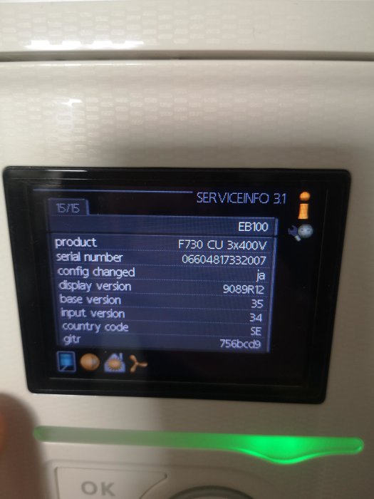 Display på en värmepumps kontrollpanel som visar serviceinformation och olika inställningar.