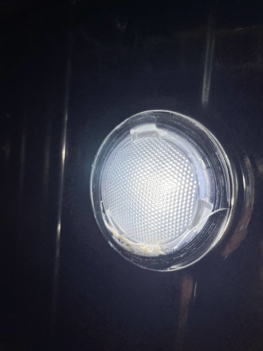 Close-up av en sprucken och läckande lampa med synliga sprickor och fuktskador.