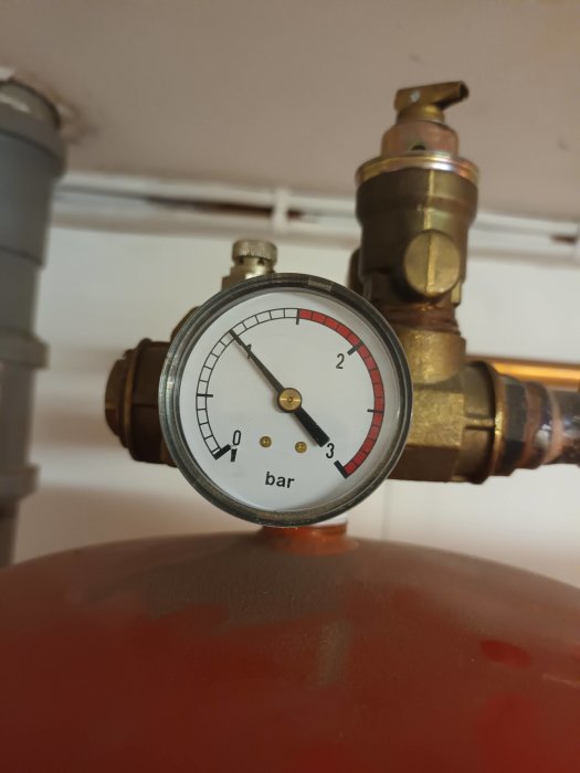 Tryckmätare vid 1,5 bar på en röd expansionskärl i en VVS-installation.