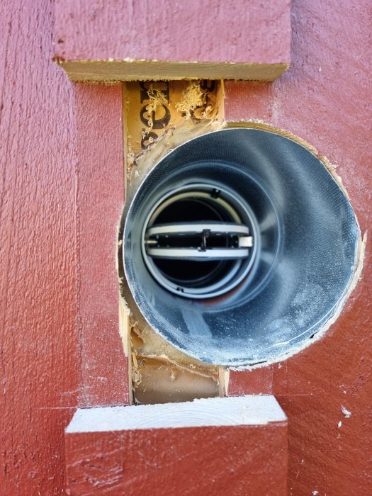 Ventilationsrör installerat i vägg med synlig isolering och ojämnt skuren öppning.