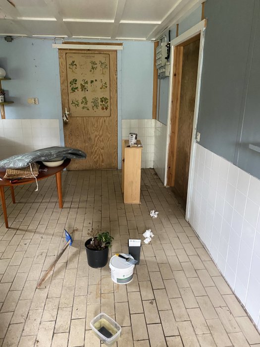 Ett pågående renoveringsprojekt i ett tomt rum med byggmaterial och verktyg på golvet.