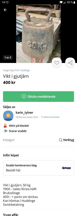 Gammal gjutjärnsvikt på 50 kg med rostigt handtag, lämplig för ensidig styrketräning.