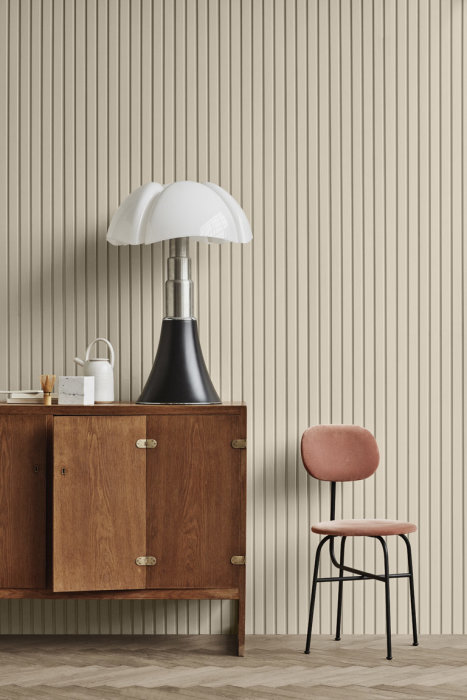 Puusenkki, vaaleat pystyrimat seinällä, mustavalkoinen pöytävalaisin ja vaaleanpunainen tuoli.