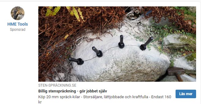 Sten med borrade hål och insatta spräckkilklar för stenspräckning i trädgårdsmiljö.