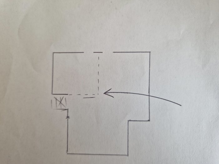 Handritad skiss av en rumslayout med markerad väggöppning och pil.