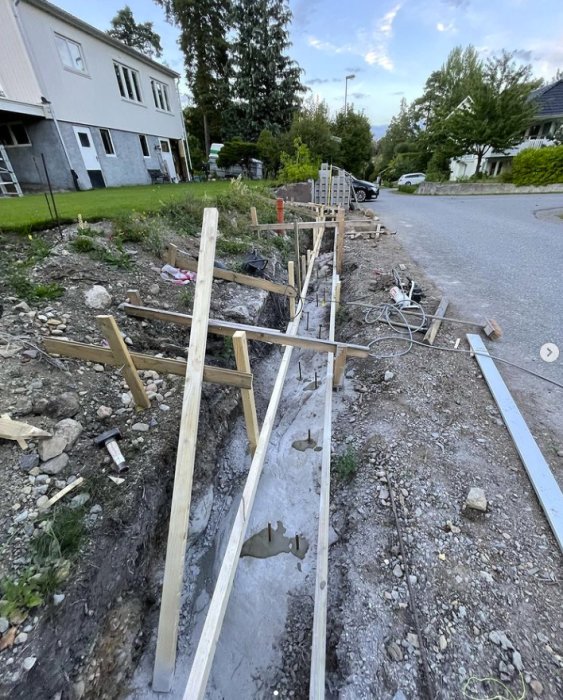 Pågående arbete med stödmur, utgrävning och formar av reglar uppförda på bergsgrund.