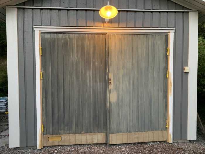 Garageport målad med Jotun Drygolin grund, sparkplåtar borttagna, under förberedelse inför slutstrykning.