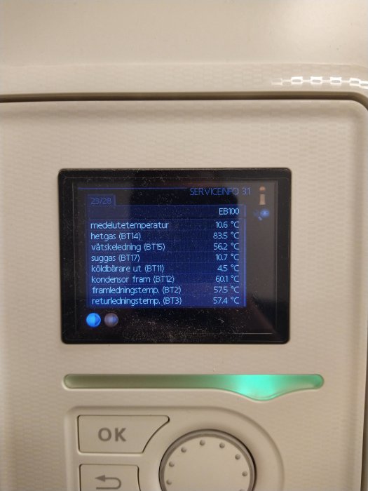 Displaypanel på en värmepump som visar temperaturdata och serviceinformation.