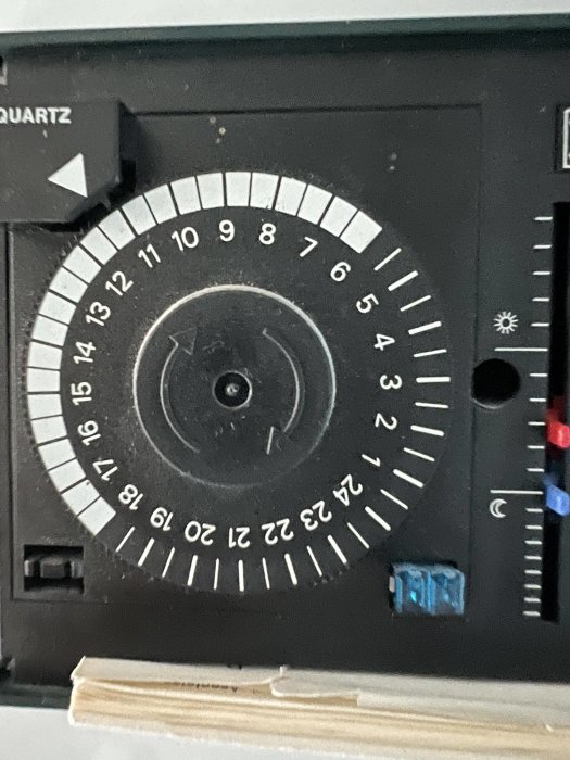 Närbild av en anslagstimer med analoga urtavlor och inställningsmarkörer.