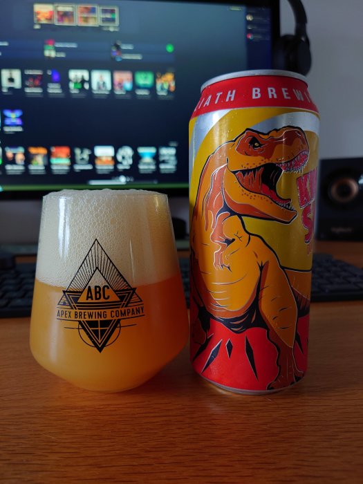 Ölglas märkt Apex Brewing Company och en burk Toppling Goliath King Sue framför en datorskärm.
