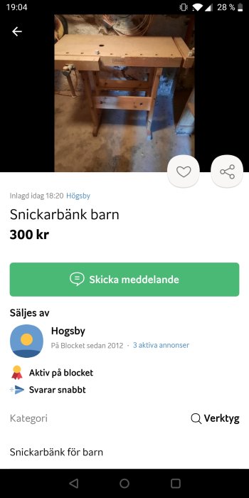 En träsvarvad snickarbänk för barn placerad i ett oinrett rum.