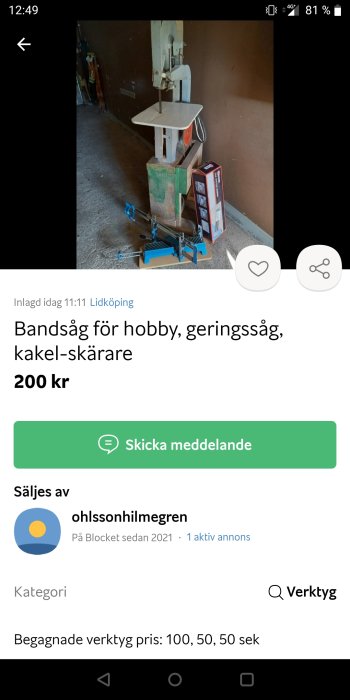 Begagnad bandsåg för hobbybruk står på ett golv bredvid en kartong, angivet pris 200 kr.