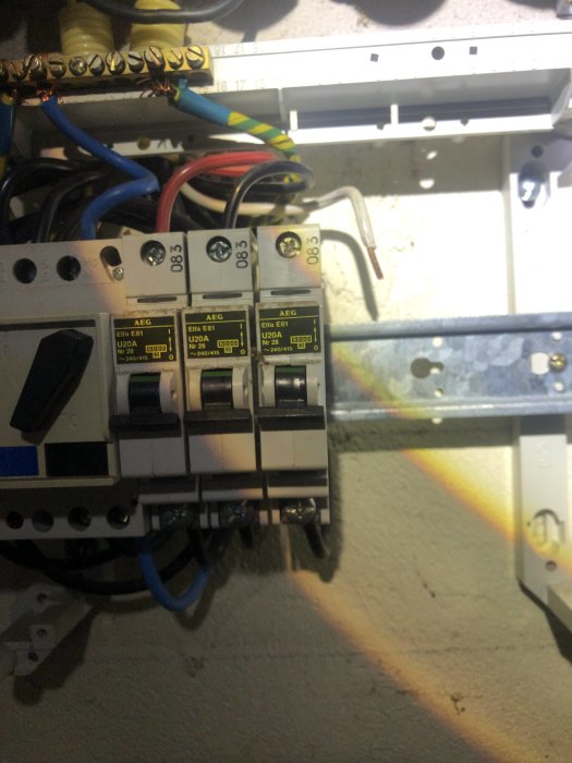 Elektrisk installationspanel med synliga ledningar och säkringar, tecken på värmeutveckling på plasthållare.