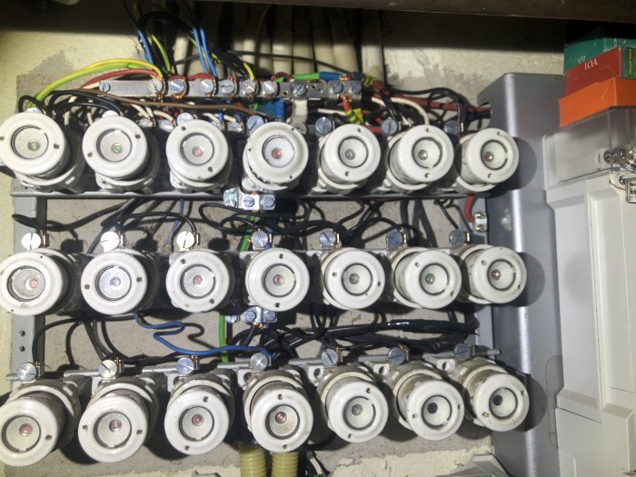 Översikt över en elektrisk central med flera säkringar och kablar med olika färger som är anslutna till enheterna, några ledningar är tejpade.