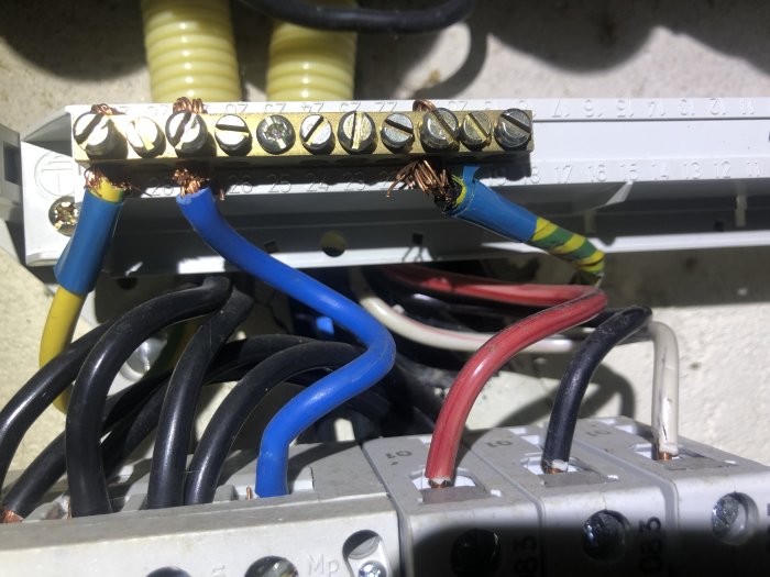 Elcentral med synligt skadade och felaktigt anslutna ledare med olika färger.