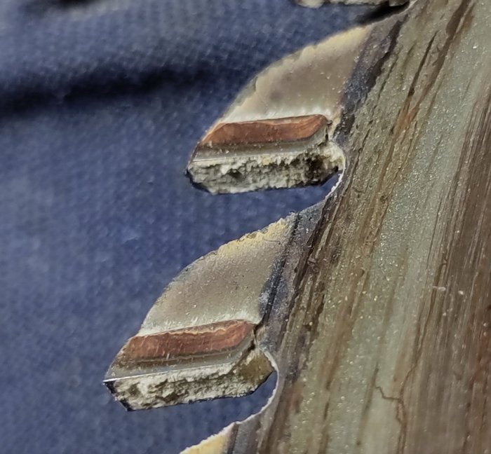 Närbild på skadat trä med synlig träskiva och fuktskador