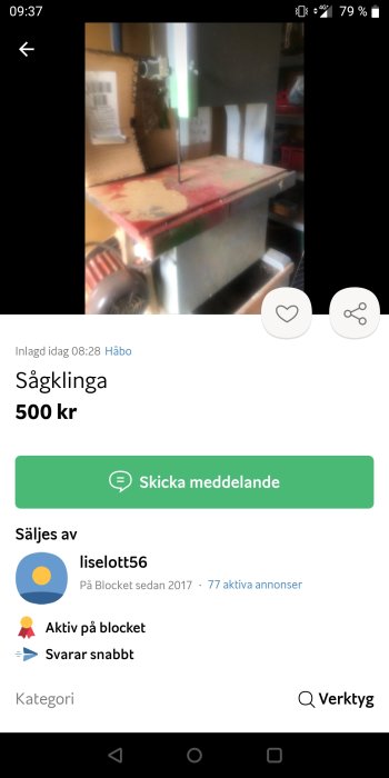 Bandsåg med röd och grön bordsyta upplyst i ett verktygsrum, skärmen visar en Blocket-annons.