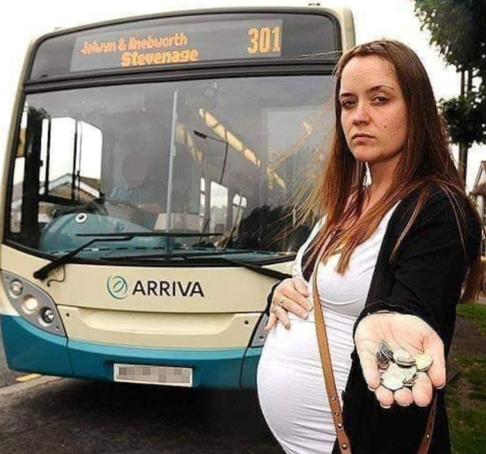 Gravid kvinna framför en buss visar upp mynt i handen.