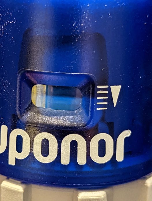 Närbild på Uponor-rördel med vattenbubblor och logo.