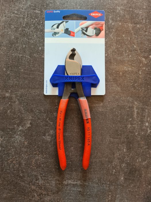 Knipex tång med orangeröda handtag på en förpackning med varumärkets logotyp.