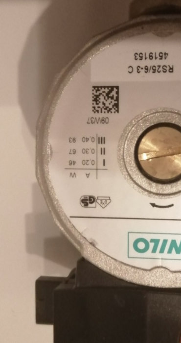 Närbild av en pumpmotors etikett med tekniska specifikationer och QR-kod.