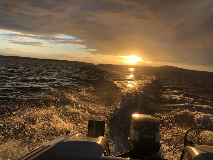 Solnedgång sett från en båt med Yamaha-motor, utsikt över vågor och horisont mot kvällshimlen.