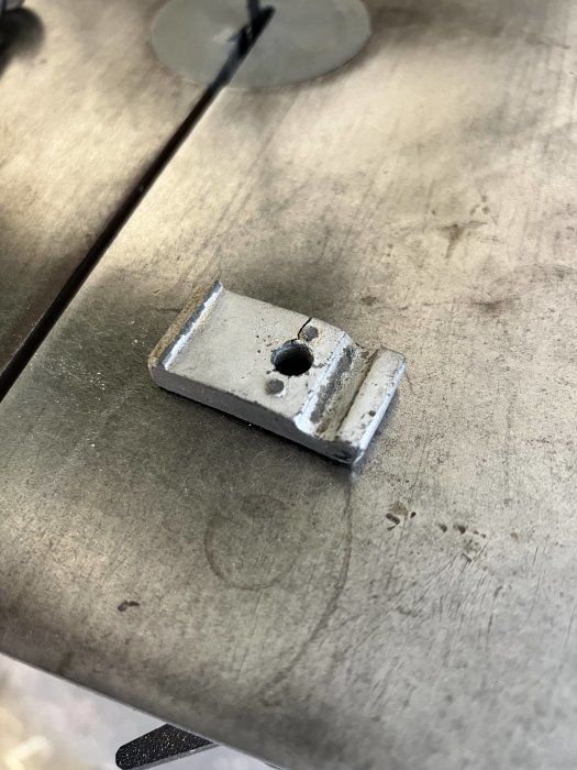 Sprucket metallhus på en arbetsbänk, en del till ett större byggprojekt med synliga skador och hål.