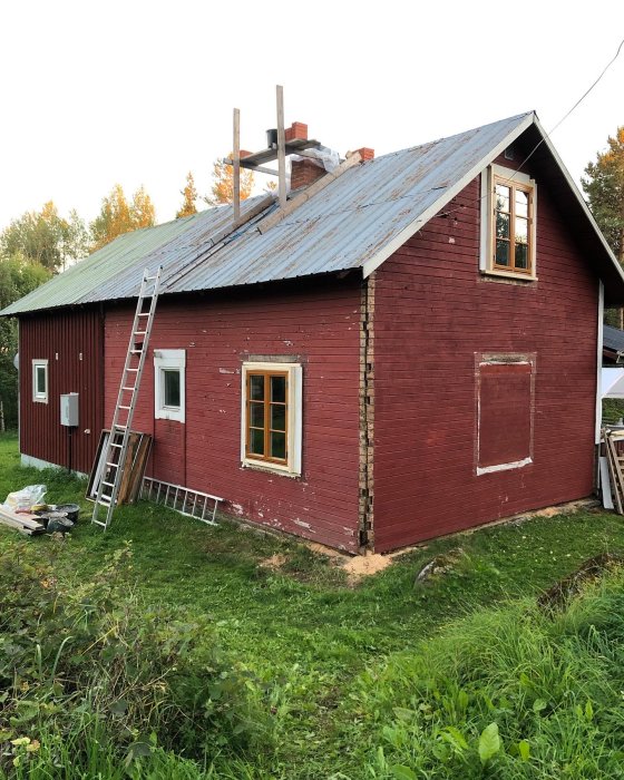 Renoverat rött hus med nya fönster från Sunnerbo, byggnadsmaterial och stege på sidan.