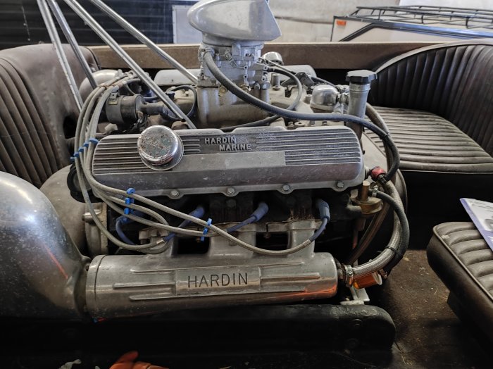 Klassisk Hardin Marine motor i en båt med sittplatser runtom.