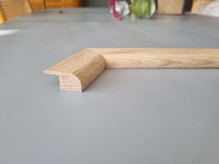 Eklisten med profil ligger på ett grått bord, fokus på den profilerade änden.